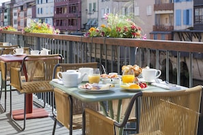 A balcony with wicker chairs and tables, breakfast spread, and flower baskets. - Best Western Grand Hotel de Castres (Castres)