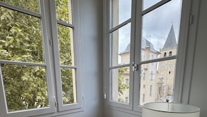 A corner room with two windows, a chair, and a table with a lamp. - Best Western Grand Hotel de Castres (Castres)