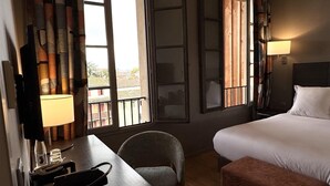 A hotel room with a bed, a desk with a chair, a TV, and a window with curtains. - Best Western Grand Hotel de Castres (Castres)