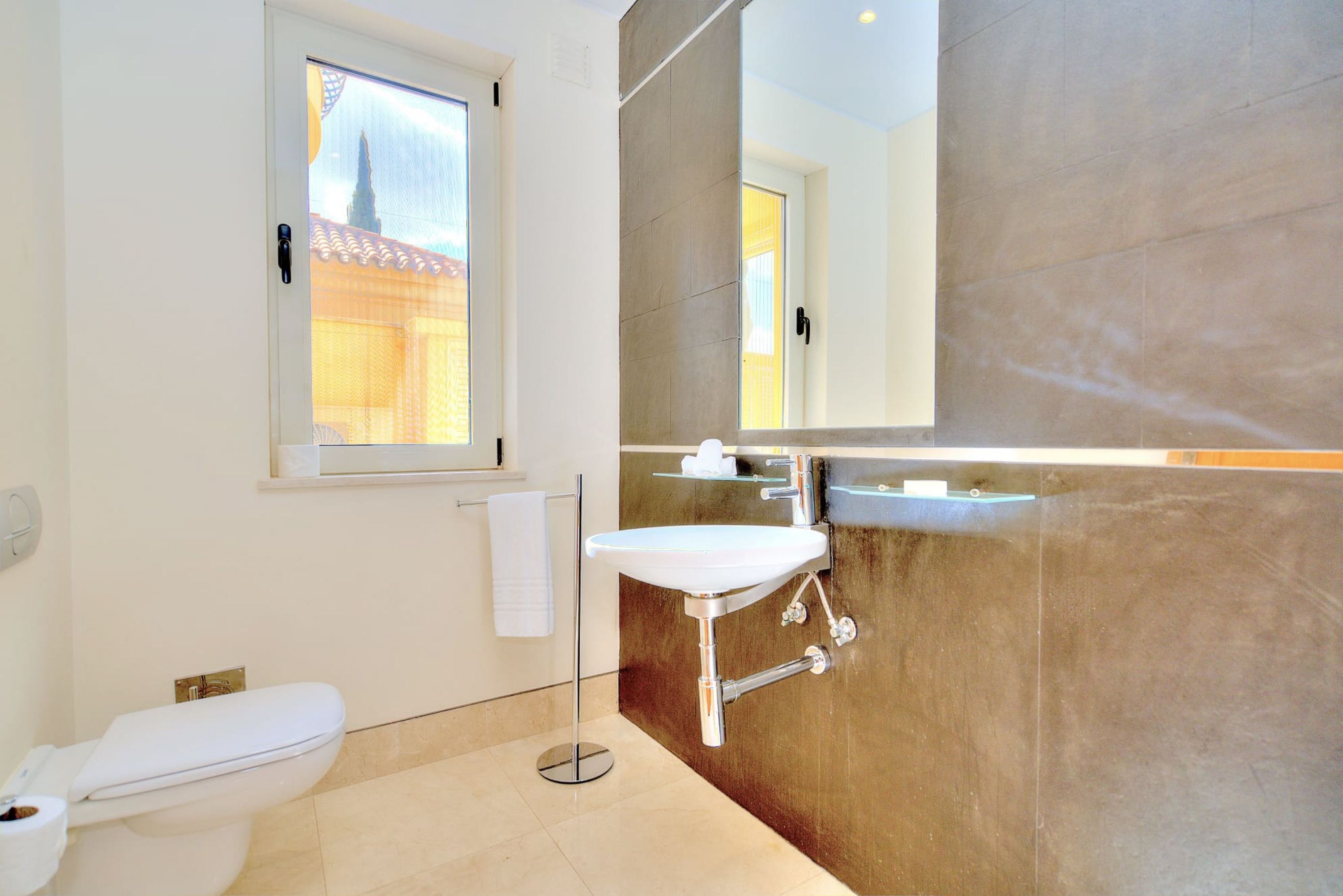 Ein Badezimmer mit Toilette, Waschbecken und großem Spiegel.