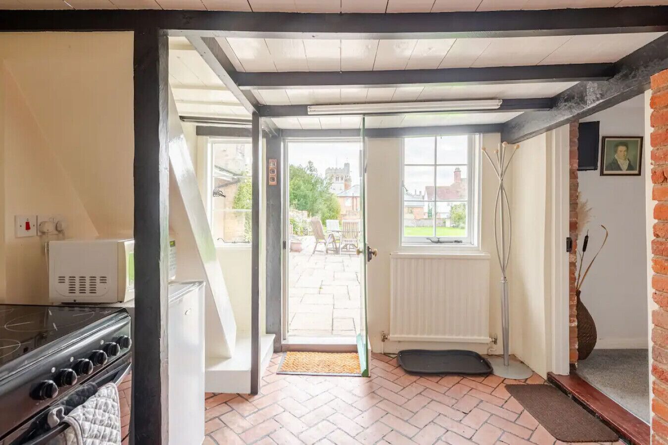 Una cucina con un fornello, un frigorifero bianco e una porta che dà su un patio.