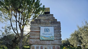 Ein Steinschild mit einem Logo und der Aufschrift 'Tratturo', das ein Bed & Breakfast kennzeichnet.