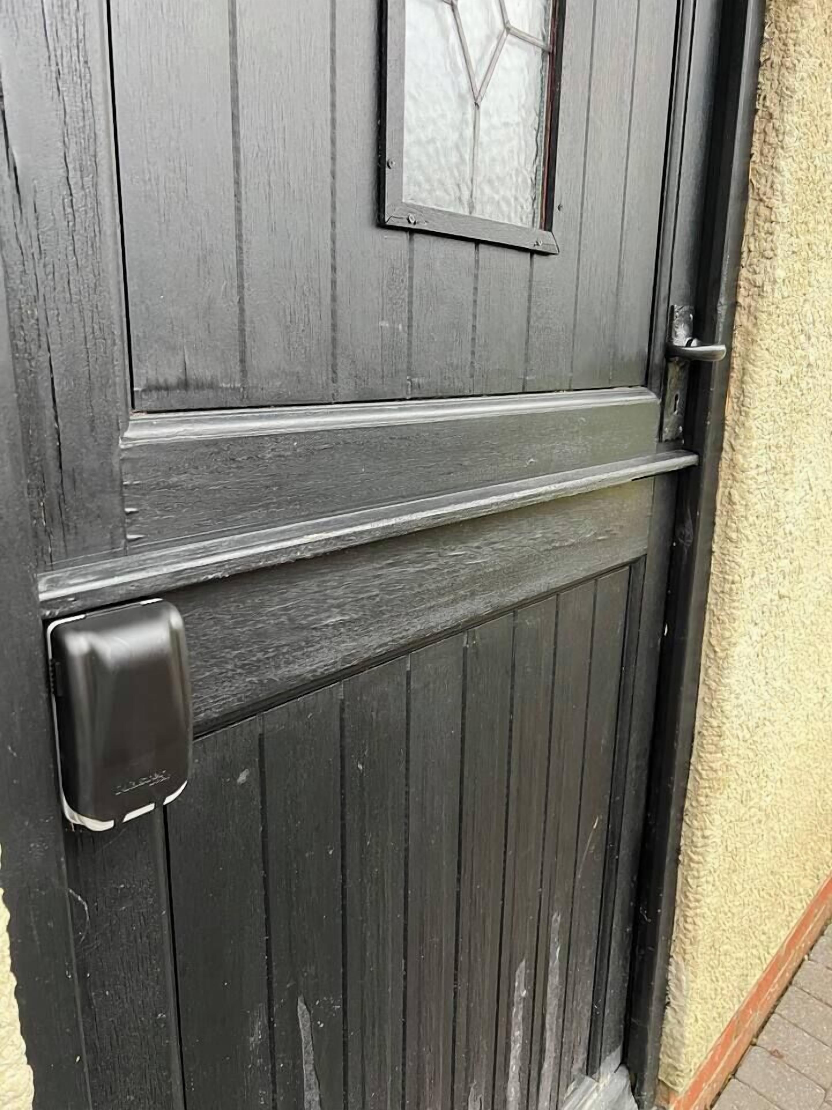 A dark wooden door with a glass panel and a metal handle.