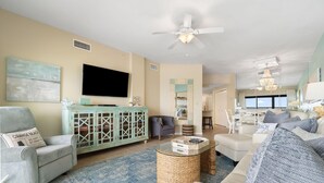 A living room with a television, a cabinet, a sofa, and a coffee table. - The Palms West 813 (Orange Beach)