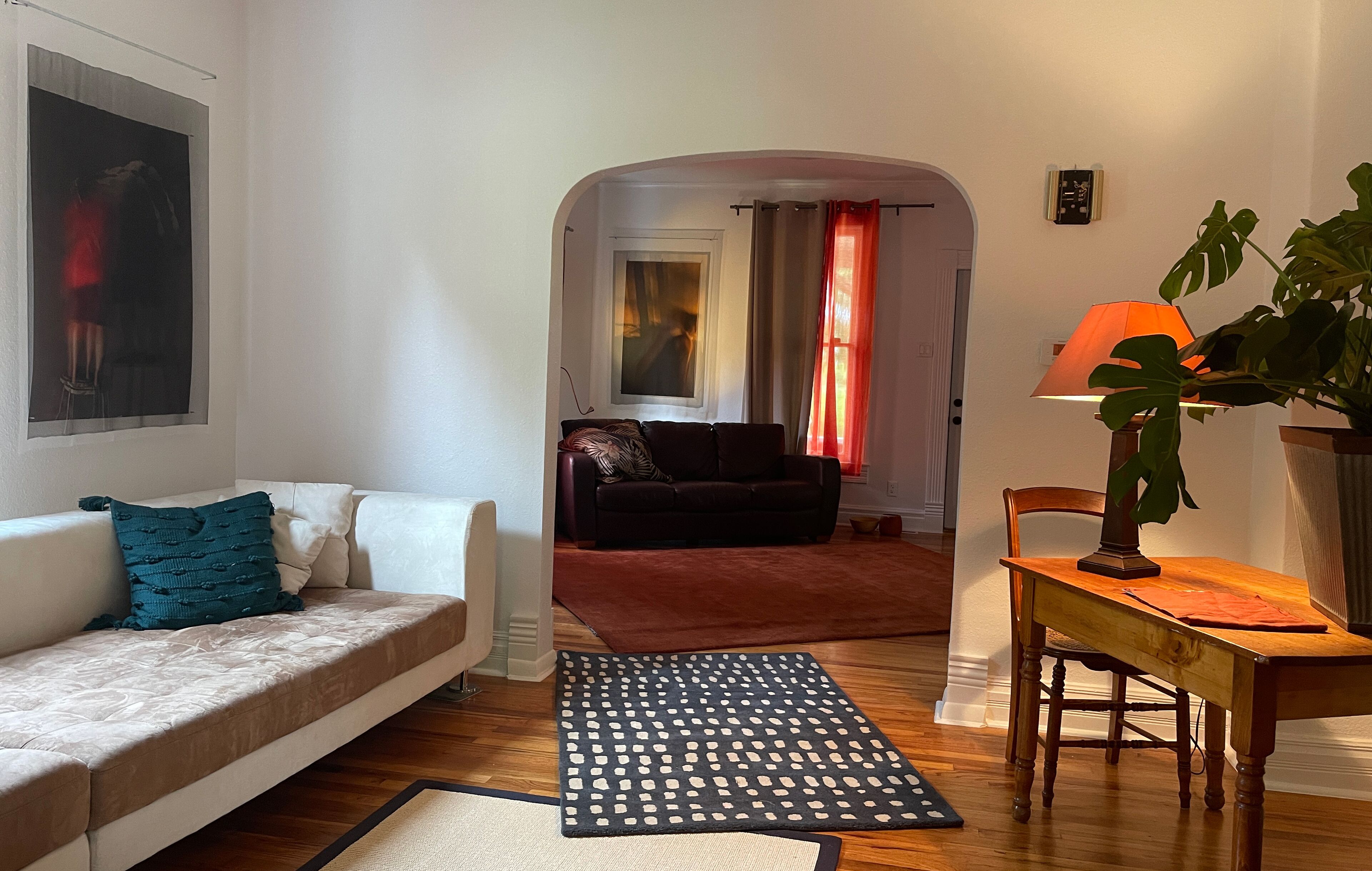 A living room with a sofa, a coffee table, a rug, and a dining table with chairs.