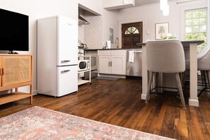 Una cocina moderna con refrigerador, microondas y mueble de madera.