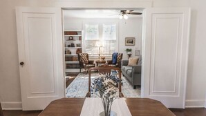 A dining area with a wooden table and a vase of flowers. - Historic Park Place Retreat  3 Bdrm on the Park (Columbus)