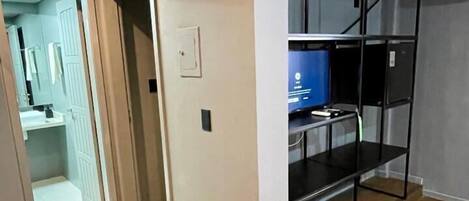 A room with a bunk bed, a small kitchenette, and a bathroom visible through an open door.