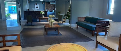 Un hall d’entrée moderne avec un comptoir d’accueil, un espace salon et un sapin de Noël.