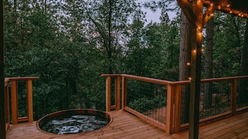 Terraza de madera con jacuzzi y barandilla de madera.