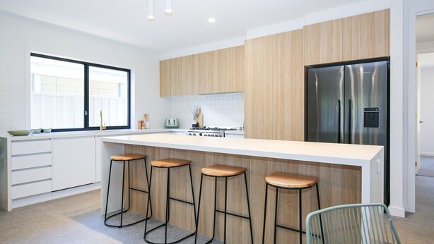 A modern kitchen with a large island, bar stools, a refrigerator, and a window. - Manning Retreat - your family haven on Gavan St (Bright)