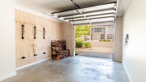 Eine Garage mit Betonboden, Holzwänden und einer Metallgaragentür.