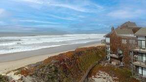 Un edificio frente al mar con varios balcones que dan a la playa y al océano.