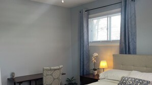 A bedroom with a bed, a desk, a chair, a nightstand, a lamp, and a ceiling fan. - Beautiful Single Family Home (Evesham)