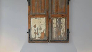 Ein Schlafzimmer mit einer gesteppten Kopfteile, einem flauschigen weißen Kissen, einer gerollten grauen Decke und zwei Nachttischlampen.