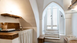 Una cocina con encimera de madera, un lavabo, una ventana con vistas y una banca.