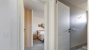 Une chambre d’hôtel comprenant un lit, une table de chevet et une œuvre d’art accrochée au mur.