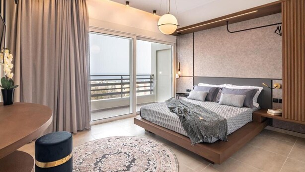 A modern bedroom with a bed, a dining table, and a view of the outdoors.