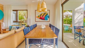 Un comedor con una mesa de madera, sillas azules y un cuadro grande de un pez.