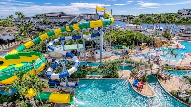 A water park with multiple slides and pools, surrounded by palm trees and buildings. - Jacks Blue Haven- 3/2 Heated Pool, Game Room & Close to Gulf Beaches!!  (Largo)