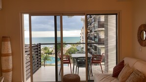 Un balcone con vista sull'oceano e su una zona piscina.
