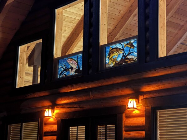 A building with wooden beams and stained glass windows depicting fish.