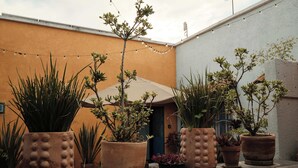 Een binnenplaats met potplanten en een lichtslingering.