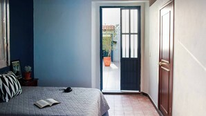 A bedroom with a bed, a door, and a view of the outside. - Casa Arrayán 3 Private Room / Private Bathroom  (Guadalajara)