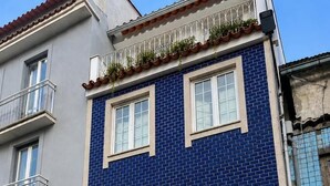 A blue-tiled building with two doors labeled '155' and '157,' and a sign indicating 'Casa Augusta Hostel.' - Casa Augusta 6 (Braga)