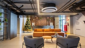 A modern interior with a sectional sofa, two armchairs, a coffee table, and a Christmas tree. - Flat Way Style - By Almare (João Pessoa)