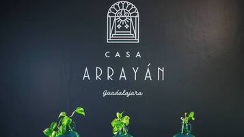 A logo with 'CASA ARRAYÁN' and 'Guadalajara' text, and three green potted plants.