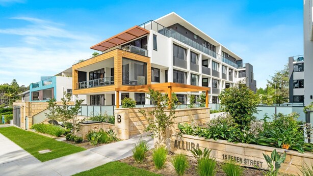 A modern multi-story residential building with balconies, a garden area, and a clear sky. - Allura Bella, Jervis Bay (Huskisson)
