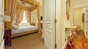 A luxurious bedroom with a four-poster bed, a bedside table with a lamp, and a large mirror on the wall. - Magnifica residenza a Campo de' Fiori (Rome)