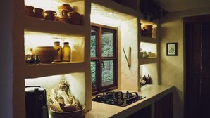 A kitchen with shelves holding various kitchenware, a window, and a stove. - Nutabe House, Girardota 40 min from Medellín! Ideal house for families and friends  (Girardota)