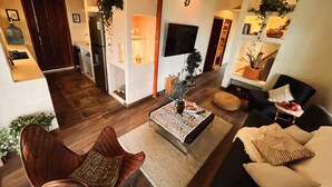 A modern living room with a sofa, armchair, coffee table, and a TV. - Nutabe House, Girardota 40 min from Medellín! Ideal house for families and friends  (Girardota)