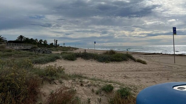 A beach with a wooden walkway and a signpost. - Cozy apartment in Gava Mar. (Gavà)