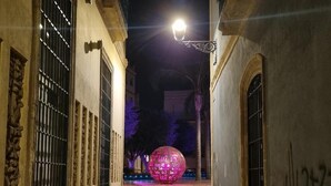 A narrow alleyway with a spherical light installation at the end. - Newly renovated penthouse in the historic center of Almeria. (Almería)