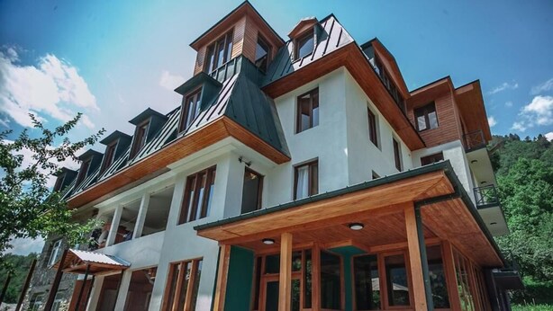 A multi-story house with a prominent attic, large windows, and a covered porch area. - latour Mestia (Mestia)