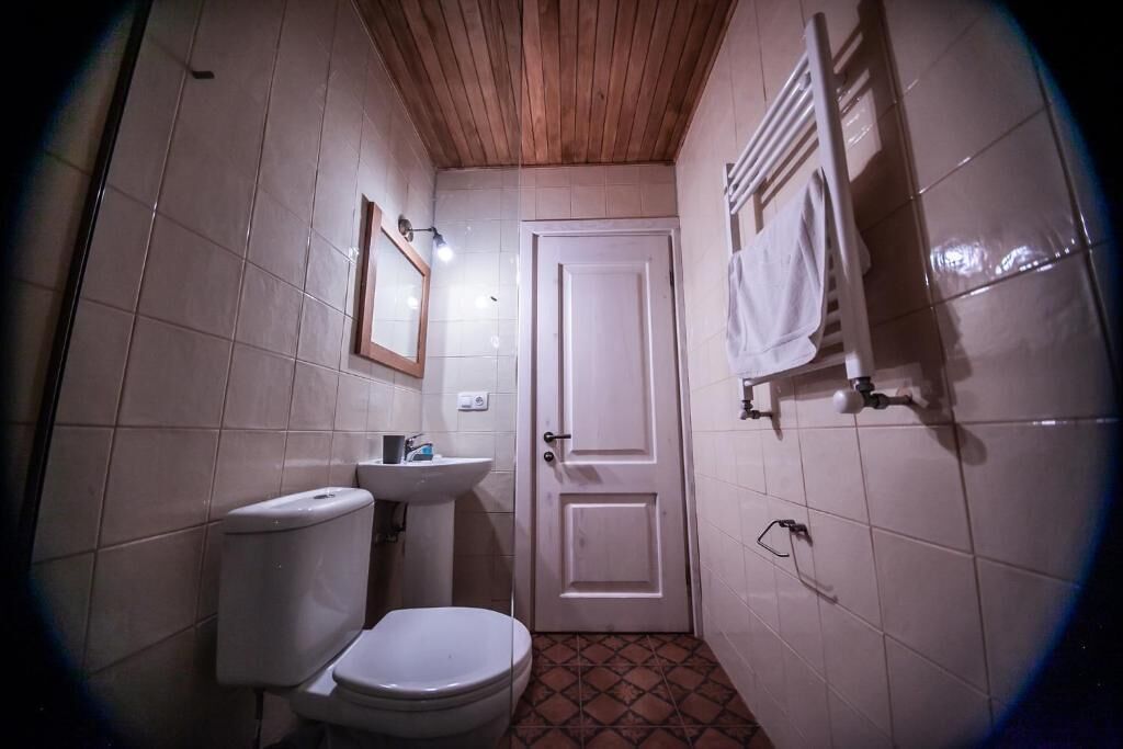 Une petite salle de bain avec des toilettes, un lavabo et une porte.