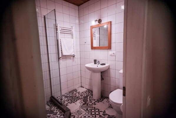 A small bathroom with a white sink, a mirror, and a toilet. - latour Mestia (Mestia)