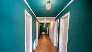 A hallway with teal walls, wooden flooring, and white doors. - latour Mestia (Mestia)