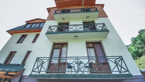 A multi-story building with a modern architectural design, featuring balconies with metal railings and a flat roof. - latour Mestia (Mestia)