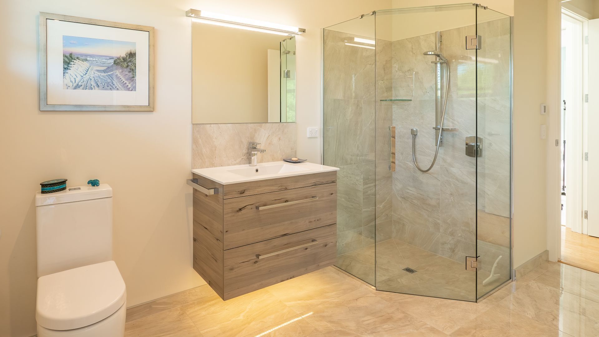 Un bagno moderno con cabina doccia in vetro, un mobile bagno in legno e un water.