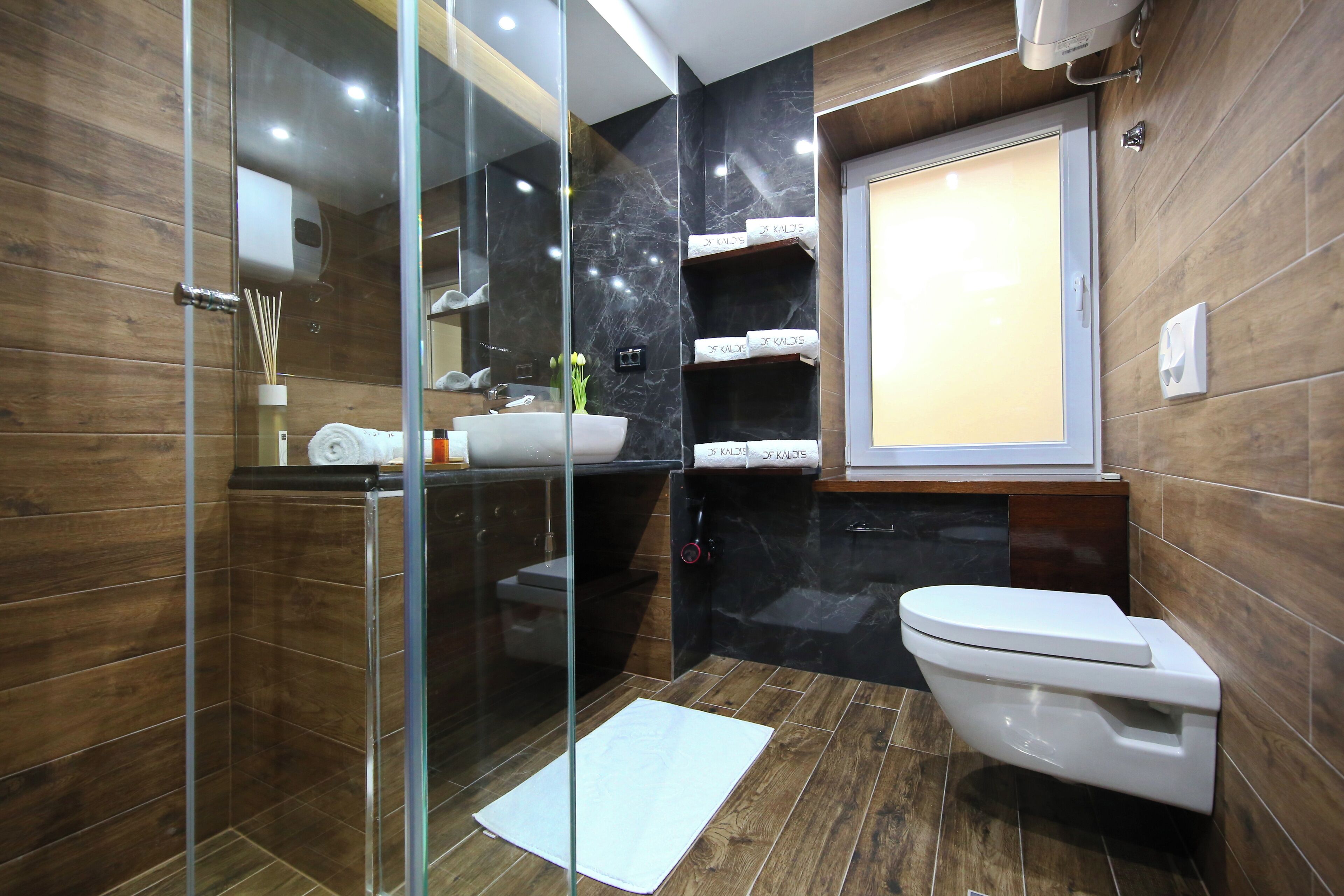 A modern bathroom with a glass shower enclosure, a white toilet, and a vanity with a sink.