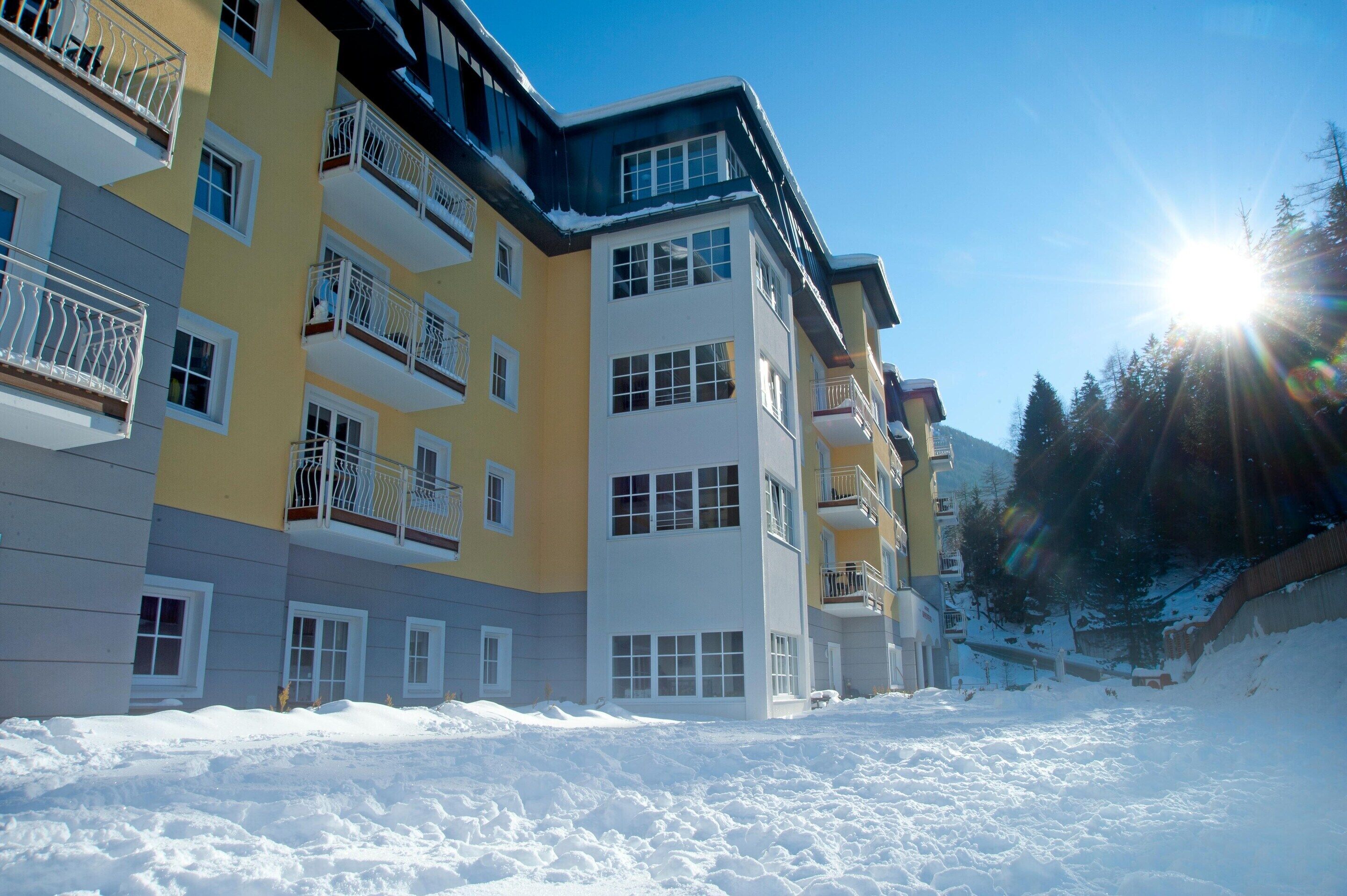 Un hôtel à plusieurs étages, doté de balcons, qui offre une vue sur un paysage enneigé.