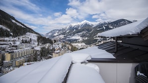 A snow-covered mountain landscape with buildings in the foreground and a clear sky. - Apartment in Salzburg Near Ski-lift (Bad Gastein)