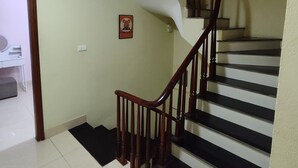 A staircase with wooden railings and black steps, leading to an upper floor. - J&J guest house (Hanoi)