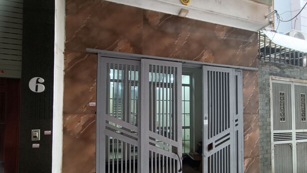 A building entrance with a numbered door, metal gates, and a marble wall. - J&J guest house (Hanoi)
