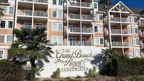Ein mehrstöckiges Gebäude mit Balkonen, beschriftet mit "The Grand Beach Resort Condominium".