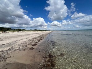 A beach with clear water, sandy shore, and a partly cloudy sky. - 4 Star Holiday Home in Vaeggerlose (Vaeggerlose)